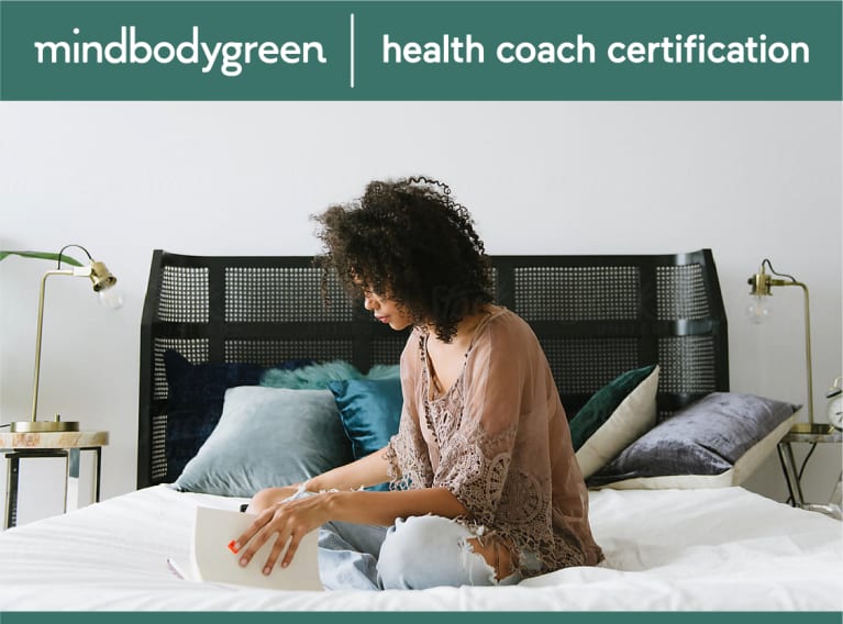woman sitting at laptop with mbg health coaching logo above