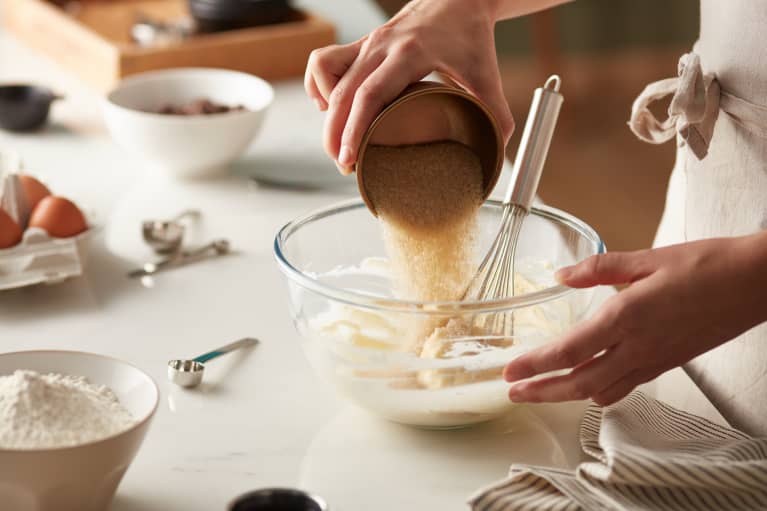 Brown sugar being poured into dough