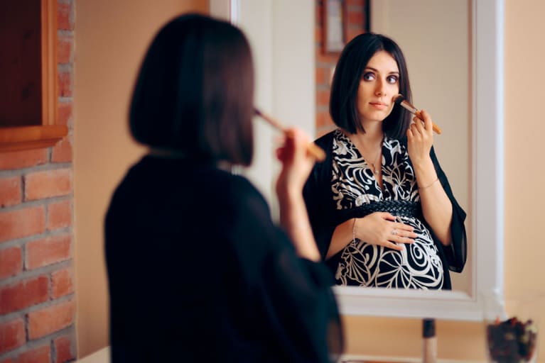 pregnant woman using makeup