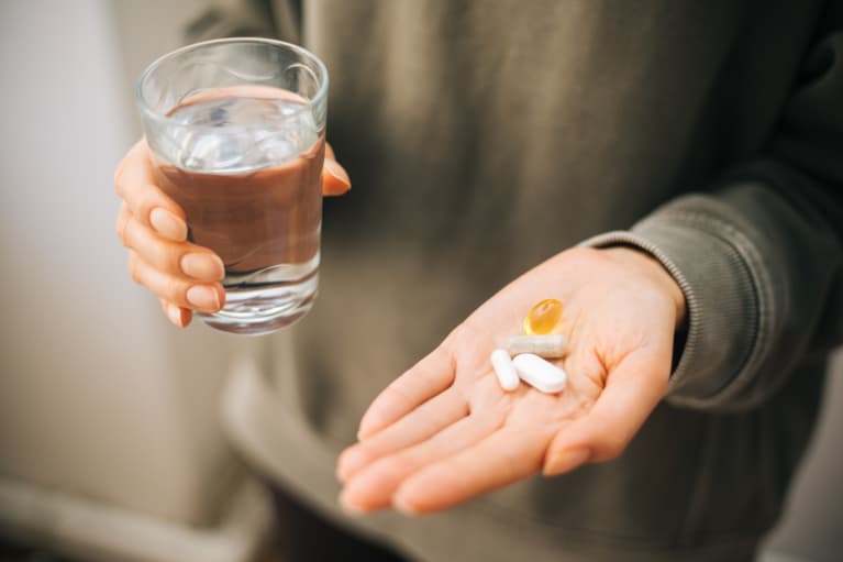 A hand holding a bunch of pills in an open palm stock photo...