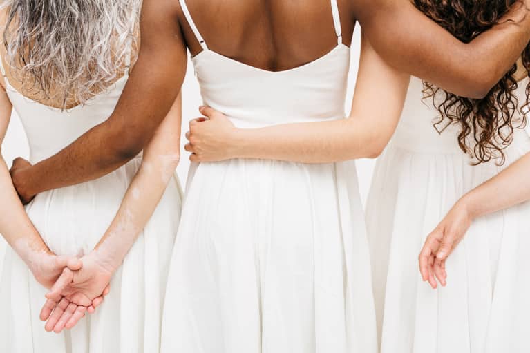 Mixed race women with hands on each other's backs