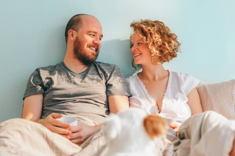 Couple Looking Kindly at One Another In Bed on a Sunny Morning