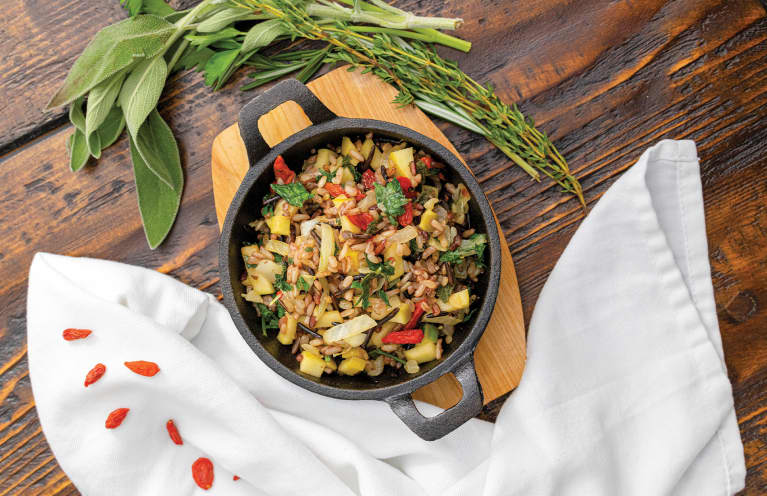 wild rice stuffing with apples and herbs in a cast iron pot
