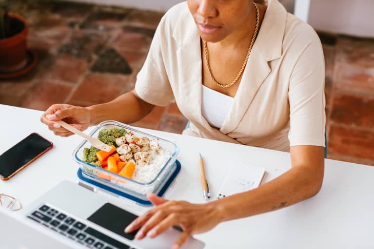 Unrecognizable Woman Eating at Her Desk