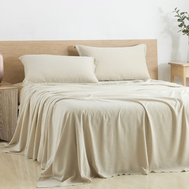bed made with soft, cream-colored sheets