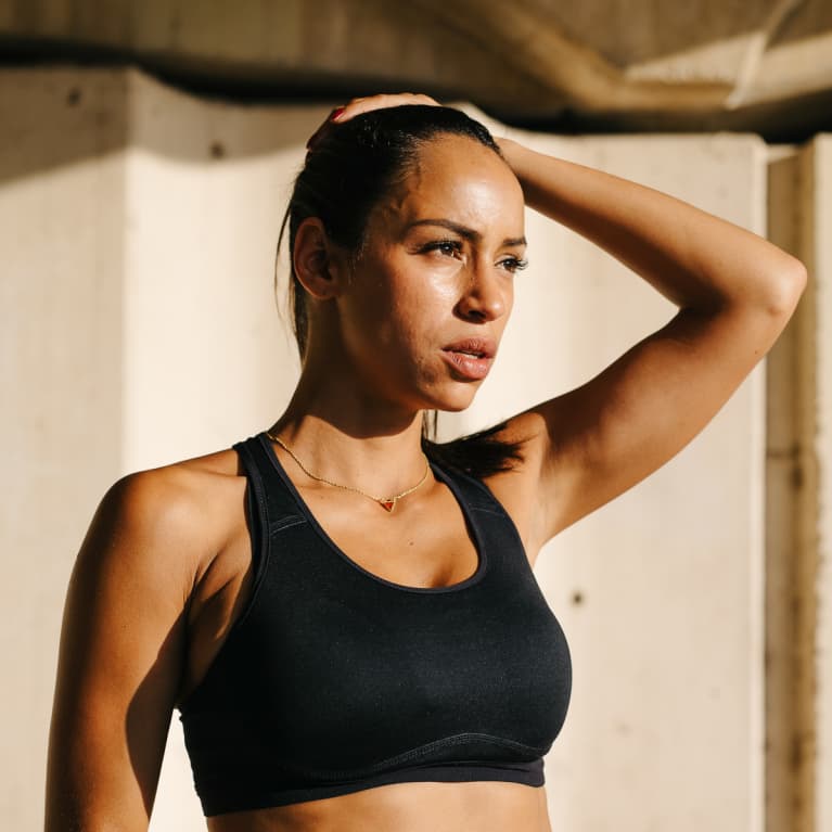 Confident sportswoman looking away in sunlight