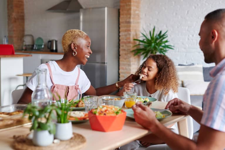 family eating nutritious meal together at dinner table