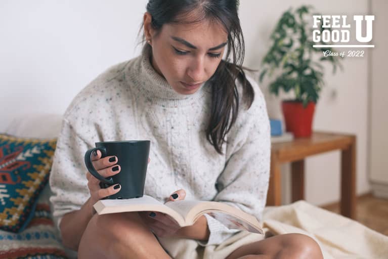 cozy woman reading book with cup of tea tea in hand