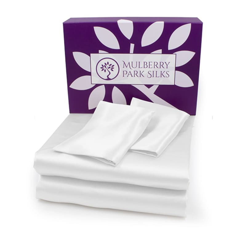 white silk sheets folded in front of purple box white silk sheets folded in front of purple box