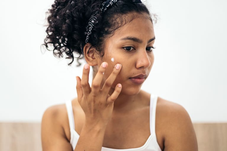 woman putting on skincare