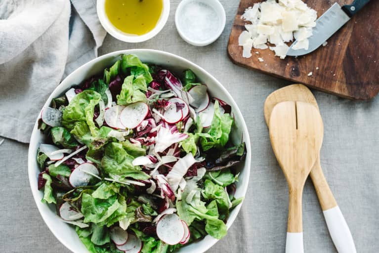 Radish and lettuce salad with chopping board, olive oil,, salt and utensils