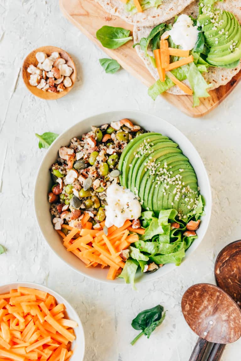 A High-Fiber Diet May Reduce Your Risk Of Deadly Diseases, Study Finds Overhead-of-a-grain-bowl-with-avocados-seeds-carrots-and-other-ingredients