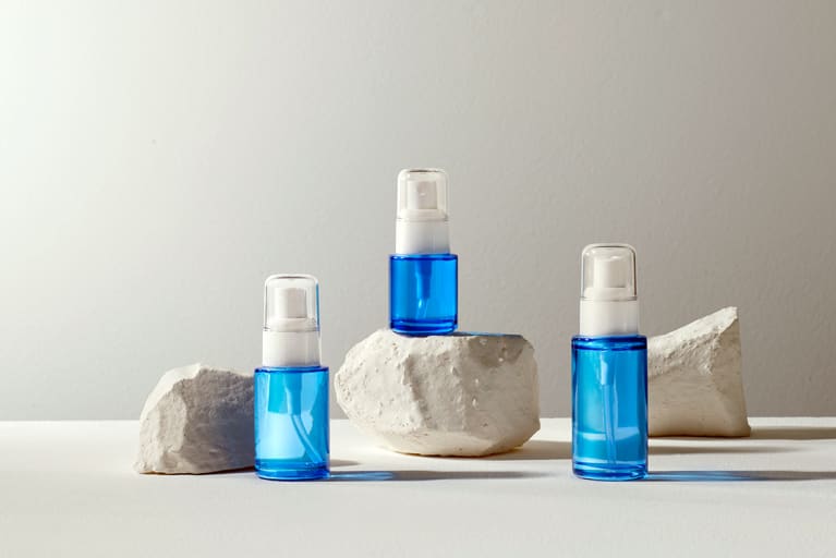 Skincare cosmetics bottles on gray concrete block