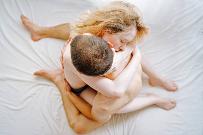 An image of a couple having tantric sex in the yab yum position.