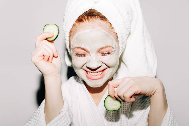Woman in a Robe and Towel Doing a Cucumber Face Mask