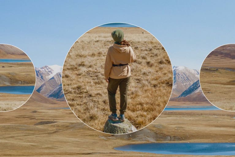 Female hiker stand outdoors in stunning mountain nature landscape enjoying her adventure trip