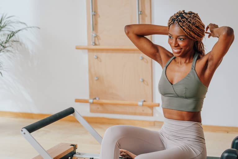 Yoga Vs. Pilates: We Got To The Core Of Which Workout Is Better For You Fit Woman in a Pilates Studio
