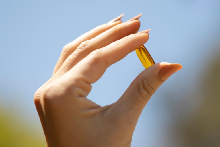 Hand holding mindbodygreen vitamin D3 supplement