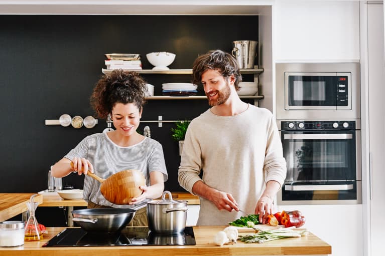 Happy young couple cooking together in kitchen