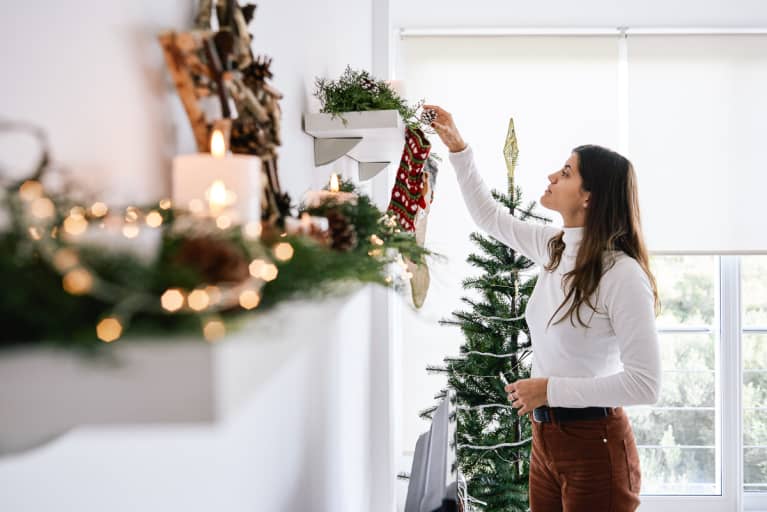 https://mindbodygreen-res.cloudinary.com/images/w_767,q_auto:eco,f_auto,fl_lossy/org/sflx52d23k3ue6xjn/young-woman-at-home-putting-up-holiday-decorations.jpg