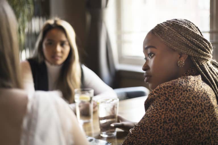 Young woman listening to her friends in a cafe bar Young woman listening to her friends in a cafe bar