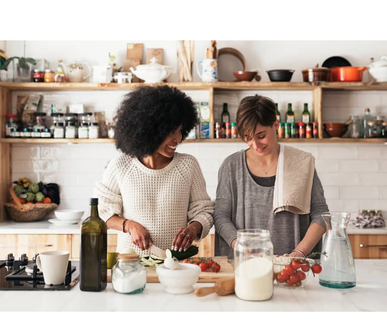 two women cooking together in the kitchen