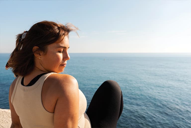 profile of a woman with closed eyes in front of the ocea