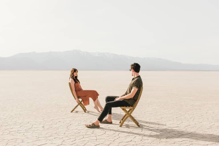 man and woman sitting in desert