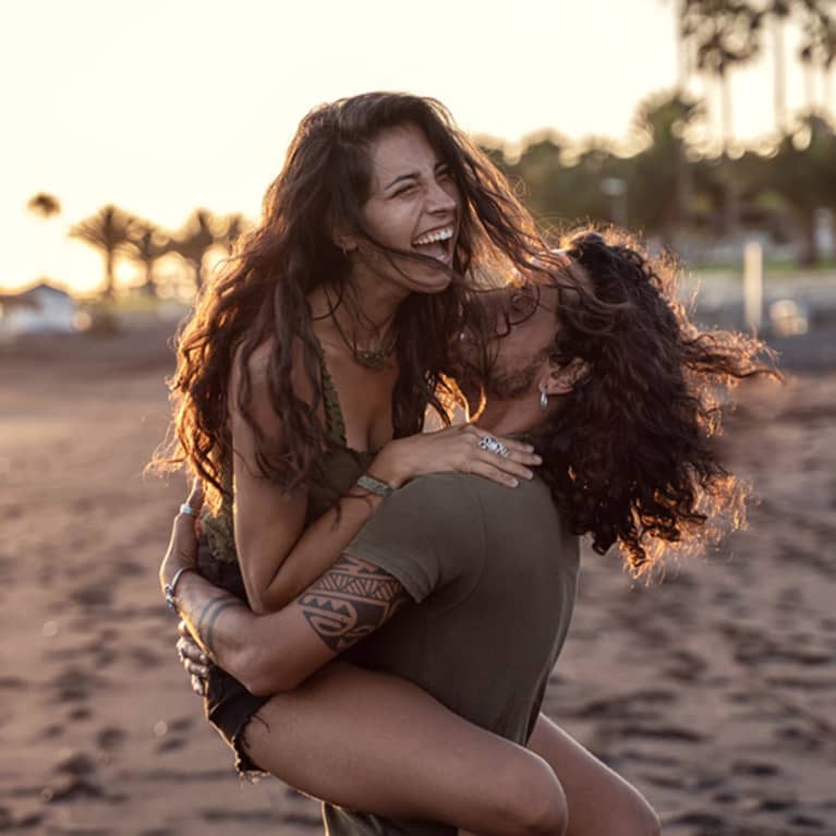 Couple laughing at the beach.