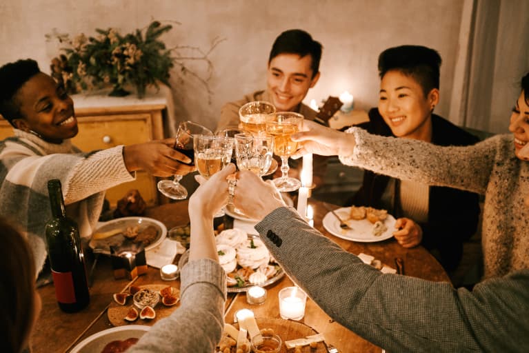 Group of Friends Gathered Around a Dining Table Cheersing