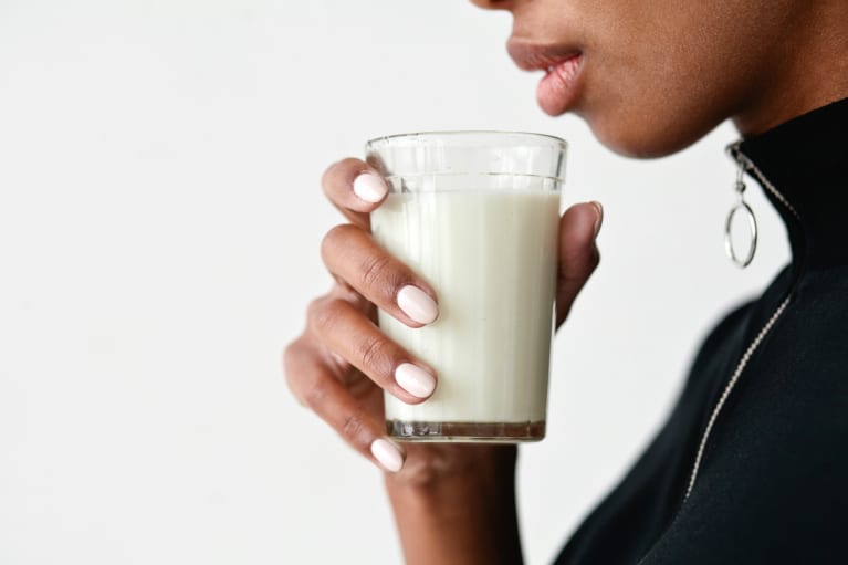 woman holding a glass of hemp milk