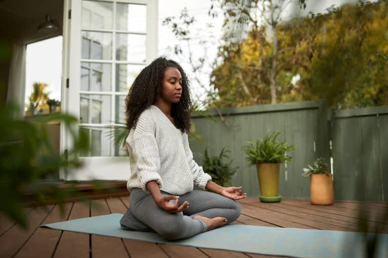 young black woman meditating outside