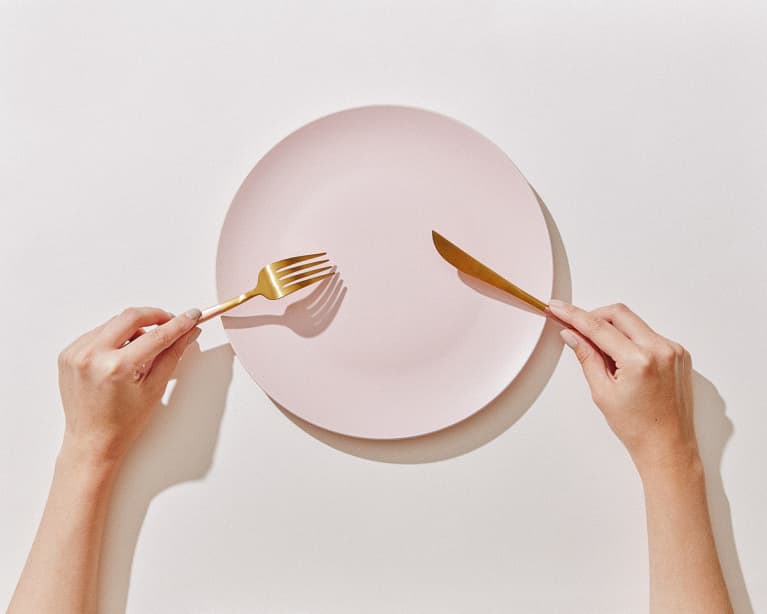 Hand with Fork and Knife and Empty Plate