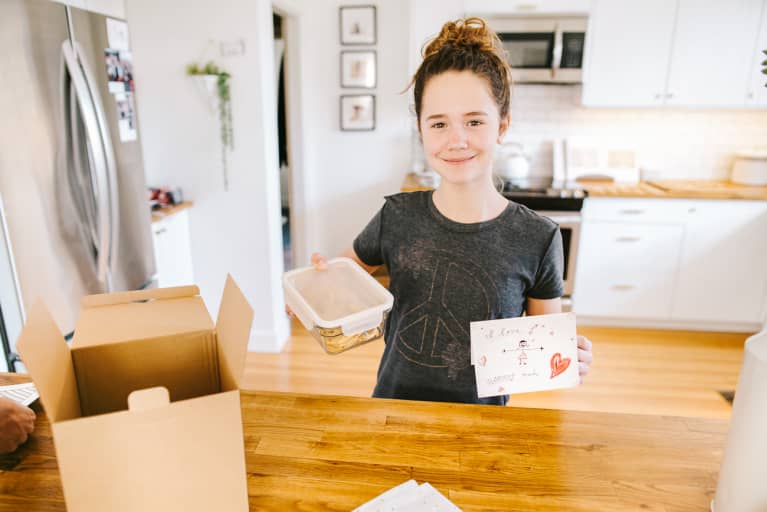 Girl Holding a Container of Baked Goods and a Handwritten Card For a Care Package