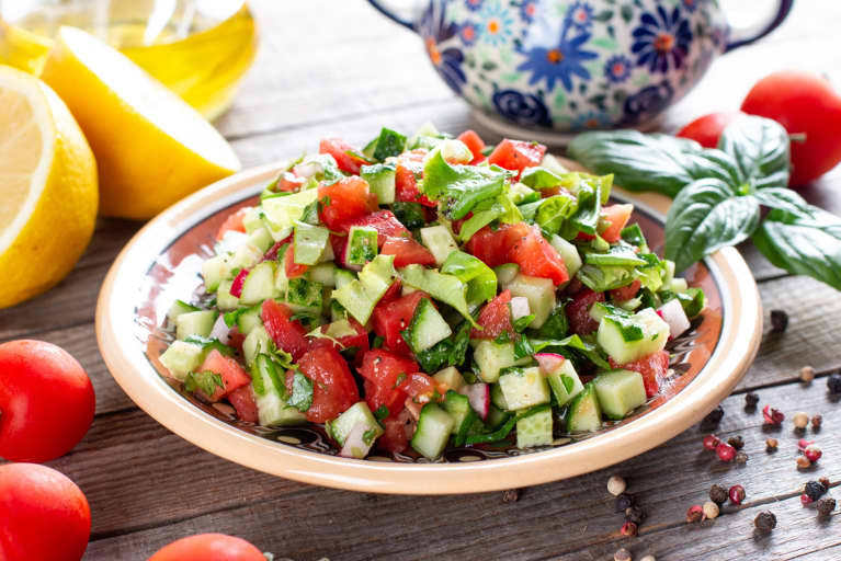 Delicious traditional Fattoush or bread salad with pita croutons, cucumber, tomato, lettuce and herbs on plate
