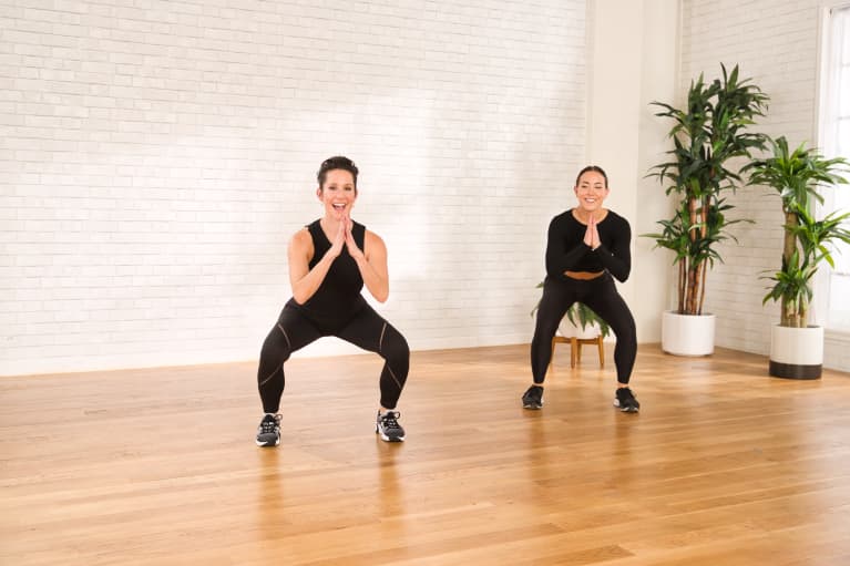 two women doing squating exercise