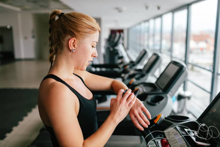 (Last Used: 1/5/21) Woman Checking Her Fitness Tracker at the Gym